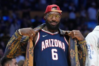 Los Angeles, California, USA; Los Angeles Lakers forward LeBron James poses in the Arizona Wildcats jersey of his son Bryce James (6) during the game against the Minnesota Timberwolves at Crypto.com Arena. Mandatory Credit: Kirby Lee-Imagn Images