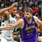 Milwaukee, Wisconsin, USA; Los Angeles Lakers guard Luka Doncic (77) drives to the basket against Milwaukee Bucks forward Giannis Antetokounmpo (34) in the third quarter at Fiserv Forum. Mandatory Credit: Benny Sieu-Imagn Images
