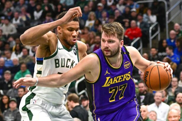 Milwaukee, Wisconsin, USA; Los Angeles Lakers guard Luka Doncic (77) drives to the basket against Milwaukee Bucks forward Giannis Antetokounmpo (34) in the third quarter at Fiserv Forum. Mandatory Credit: Benny Sieu-Imagn Images