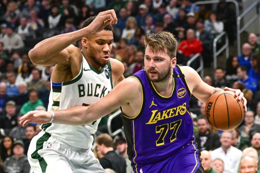 Milwaukee, Wisconsin, USA; Los Angeles Lakers guard Luka Doncic (77) drives to the basket against Milwaukee Bucks forward Giannis Antetokounmpo (34) in the third quarter at Fiserv Forum. Mandatory Credit: Benny Sieu-Imagn Images