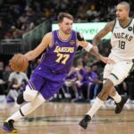 Milwaukee, Wisconsin, USA; Los Angeles Lakers guard Luka Doncic (77) drives towards the basket around Milwaukee Bucks forward Kyle Kuzma (18) during the third quarter at Fiserv Forum. Mandatory Credit: Jeff Hanisch-Imagn Images