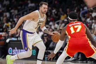 Atlanta, Georgia, USA; Los Angeles Lakers guard Luka Doncic (77) dribbles against Atlanta Hawks forward Onyeka Okongwu (17) during the first half at State Farm Arena. Mandatory Credit: Dale Zanine-Imagn Images