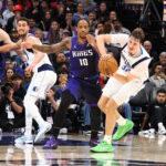 Dec 27, 2025; Sacramento, California, USA; Dallas Mavericks forward/guard Cooper Glagg (32) looks to pass the ball against Sacramento Kings forward/guard DeMar DeRozan (10) during the fourth quarter at Golden 1 Center. Mandatory Credit: Kelley L Cox-Imagn Images