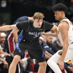 Dec 23, 2025; Dallas, Texas, USA; Dallas Mavericks forward Cooper Flagg (32) looks to move the ball past Denver Nuggets forward Spencer Jones (21) during the first quarter at the American Airlines Center. Mandatory Credit: Jerome Miron-Imagn Images