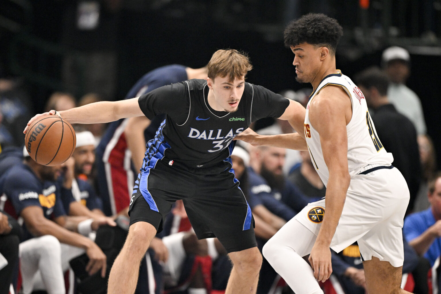 Dec 23, 2025; Dallas, Texas, USA; Dallas Mavericks forward Cooper Flagg (32) looks to move the ball past Denver Nuggets forward Spencer Jones (21) during the first quarter at the American Airlines Center. Mandatory Credit: Jerome Miron-Imagn Images