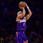 Dec 1, 2025; Los Angeles, California, USA; Phoenix Suns guard Devin Booker (1) shoots against the Los Angeles Lakers during the first half at Crypto.com Arena. Mandatory Credit: Gary A. Vasquez-Imagn Images