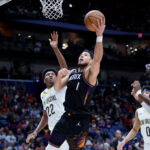 Dec 26, 2025; New Orleans, Louisiana, USA; Phoenix Suns guard Devin Booker (1) shoot against New Orleans Pelicans center Derik Queen (22) at Smoothie King Center. Mandatory Credit: Matthew Hinton-Imagn Images