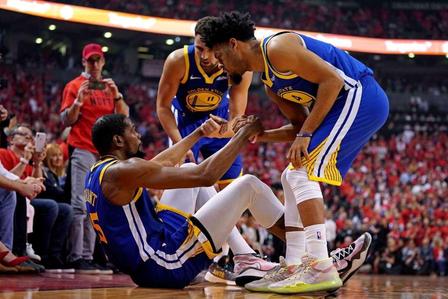 Jun 10, 2019; Toronto, Ontario, CAN; Golden State Warriors forward Kevin Durant (35) is helped up by guard Quinn Cook (4) and guard Klay Thompson (11) after an apparent injury during the second quarter in game five of the 2019 NBA Finals against the Toronto Raptors at Scotiabank Arena. Mandatory Credit: Kyle Terada-Imagn Images