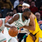 Dec 26, 2025; Indianapolis, Indiana, USA; Boston Celtics guard/forward Jaylen Brown (7) dribbles the ball while Indiana Pacers guard/forward Andrew Nembhard (2) defends in the first half at Gainbridge Fieldhouse. Mandatory Credit: Trevor Ruszkowski-Imagn Images