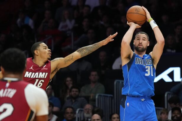Dallas Mavericks guard Klay Thompson (31) takes a three-point shot as Miami Heat forward Keshad Johnson (16) closes in during the second half at Kaseya Center.