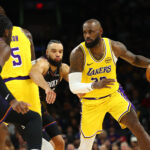 Dec 23, 2025; Phoenix, Arizona, USA; Los Angeles Lakers forward LeBron James (23) moves the ball against Phoenix Suns forward Dillon Brooks in the second half at Mortgage Matchup Center. Mandatory Credit: Mark J. Rebilas-Imagn Images