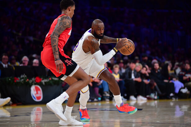 Dec 25, 2025; Los Angeles, California, USA; Los Angeles Lakers forward LeBron James (23) moves the ball against Houston Rockets forward Jabari Smith Jr. (10) during the first half at Crypto.com Arena. Mandatory Credit: Gary A. Vasquez-Imagn Images