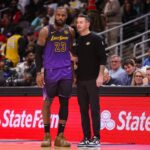 Los Angeles Lakers forward LeBron James (23) talks to head coach JJ Redick against the Atlanta Hawks in the second quarter at State Farm Arena.