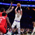 Dec 25, 2025; Los Angeles, California, USA; Los Angeles Lakers guard Luka Doncic (77) shoots against Houston Rockets center Steven Adams (12) during the first half at Crypto.com Arena. Mandatory Credit: Gary A. Vasquez-Imagn Images