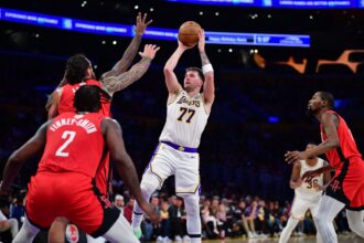 Dec 25, 2025; Los Angeles, California, USA; Los Angeles Lakers guard Luka Doncic (77) shoots against Houston Rockets center Steven Adams (12) during the first half at Crypto.com Arena. Mandatory Credit: Gary A. Vasquez-Imagn Images