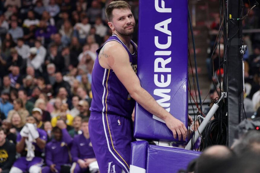 Los Angeles Lakers forward/guard Luka Doncic (77) hugs the stanchion after a foul during the first quarter against the Utah Jazz at Delta Center.