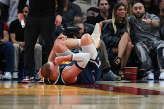 Dec 29, 2025; Miami, Florida, USA; Denver Nuggets center Nikola Jokic (15) holds his knee after an injury against the Miami Heat during the second quarter at Kaseya Center. Mandatory Credit: Sam Navarro-Imagn Images