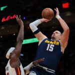 Dec 29, 2025; Miami, Florida, USA; Denver Nuggets center Nikola Jokic (15) shoots the basketball over Miami Heat center Bam Adebayo (13) during the first quarter at Kaseya Center. Mandatory Credit: Sam Navarro-Imagn Images