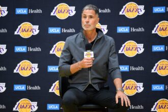 Los Angeles Lakers general manager Rob Pelinka, left, speaks during a press conference to preview the 2025-26 season at UCLA Health Training Center.