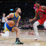 Dec 28, 2025; Toronto, Ontario, CAN; Golden State Warriors guard Stephen Curry (30) controls the ball as Toronto Raptors guard Ochai Agbaji (30) tries to defend during the third quarter at Scotiabank Arena. Mandatory Credit: Nick Turchiaro-Imagn Images