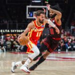 Dec 23, 2025; Atlanta, Georgia, USA; Atlanta Hawks guard Trae Young (11) dribbles the ball toward the basket against Chicago Bulls guard Coby White (0) during the first quarter at State Farm Arena. Mandatory Credit: Jordan Godfree-Imagn Images