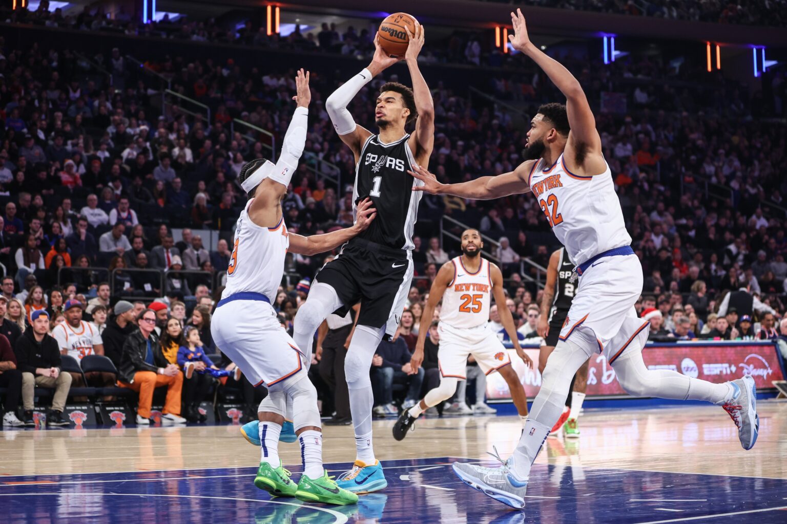 Dec 25, 2024; New York, New York, USA; San Antonio Spurs center Victor Wembanyama (1) looks to drive past New York Knicks guard Josh Hart (3) and center Karl-Anthony Towns (32) in the first quarter at Madison Square Garden. Mandatory Credit: Wendell Cruz-Imagn Images