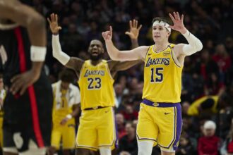 Feb 20, 2025; Portland, Oregon, USA; Los Angeles Lakers guard Austin Reaves (15) and forward LeBron James (23) signal to teammates during the second half against the Portland Trail Blazers at Moda Center. Mandatory Credit: Troy Wayrynen-Imagn Images