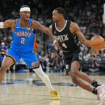 Mar 2, 2025; San Antonio, Texas, USA; San Antonio Spurs guard De'Aaron Fox (4) dribbles against Oklahoma City Thunder guard Shai Gilgeous-Alexander (2) in the first half at Frost Bank Center. Mandatory Credit: Daniel Dunn-Imagn Images