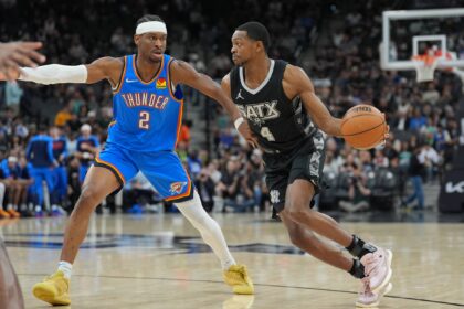 Mar 2, 2025; San Antonio, Texas, USA; San Antonio Spurs guard De'Aaron Fox (4) dribbles against Oklahoma City Thunder guard Shai Gilgeous-Alexander (2) in the first half at Frost Bank Center. Mandatory Credit: Daniel Dunn-Imagn Images