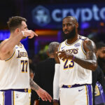 Mar 22, 2025; Los Angeles, California, USA; Los Angeles Lakers guard Luka Doncic (77) and Los Angeles Lakers forward LeBron James (23) on the sidelines against the Chicago Bulls during the first half at Crypto.com Arena. Mandatory Credit: Jonathan Hui-Imagn Images
