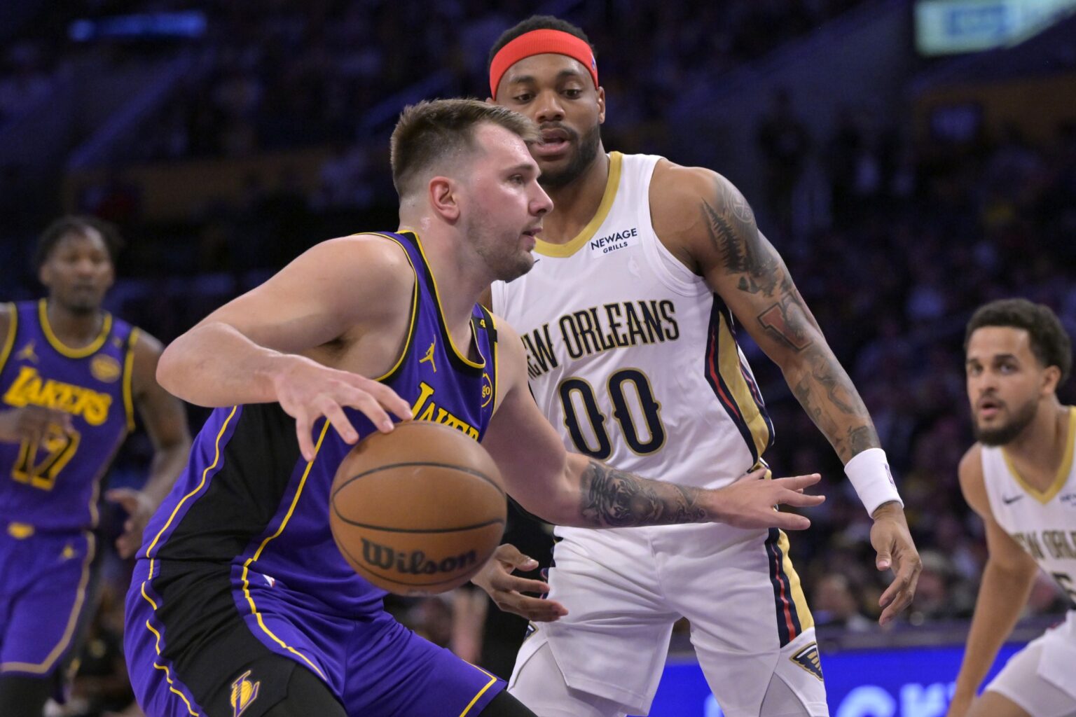 Apr 4, 2025; Los Angeles, California, USA; Los Angeles Lakers guard Luka Doncic (77) is defended by New Orleans Pelicans forward Bruce Brown (00) in the first half at Crypto.com Arena. Mandatory Credit: Jayne Kamin-Oncea-Imagn Images