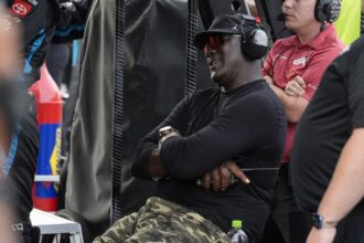 Apr 6, 2025; Darlington, South Carolina, USA; NASCAR Cup Series driver Tyler Reddick (45) team owner Michael Jordan watches his racer during the Goodyear 400 at Darlington Raceway. Mandatory Credit: Jim Dedmon-Imagn Images