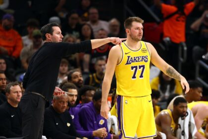 Oct 14, 2025; Phoenix, Arizona, USA; Los Angeles Lakers guard Luka Doncic (77) with head coach JJ Redick against the Phoenix Suns during an NBA preseason game at Mortgage Matchup Center. Mandatory Credit: Mark J. Rebilas-Imagn Images