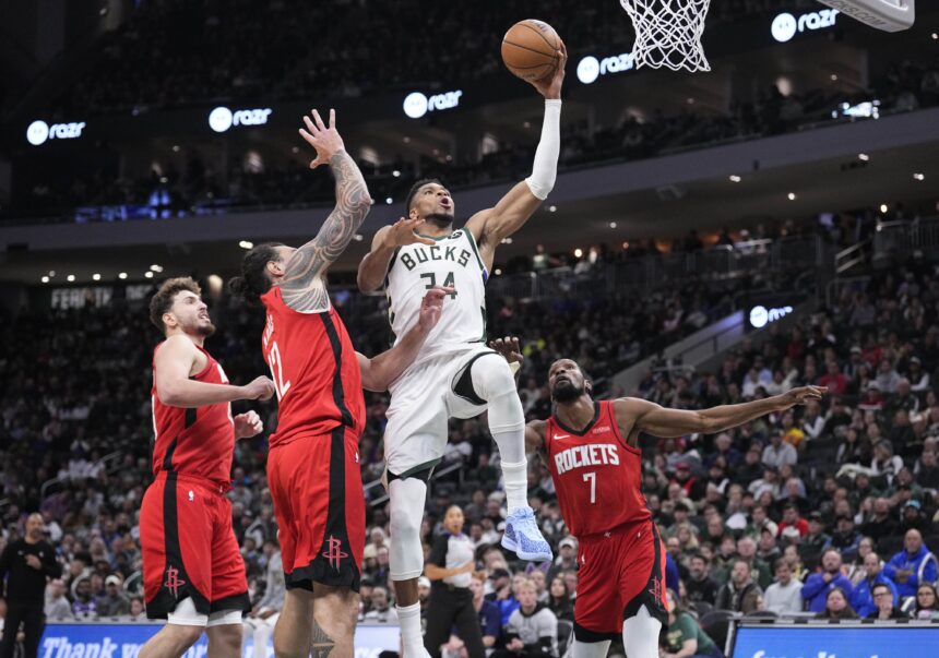Nov 9, 2025; Milwaukee, Wisconsin, USA; Milwaukee Bucks forward Giannis Antetokounmpo (34) drives to the basket against Houston Rockets center Steven Adams (12) and Houston Rockets forward Kevin Durant (7) in the second half at Fiserv Forum. Mandatory Credit: Michael McLoone-Imagn Images