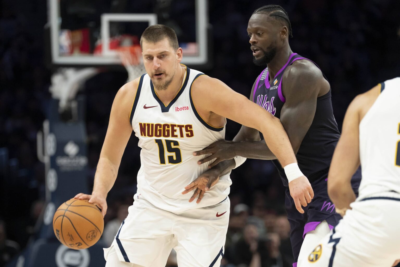 Nov 15, 2025; Minneapolis, Minnesota, USA; Denver Nuggets center Nikola Jokic (15) dribbles the ball past Minnesota Timberwolves forward Julius Randle (30) in the second half at Target Center. Mandatory Credit: Jesse Johnson-Imagn Images