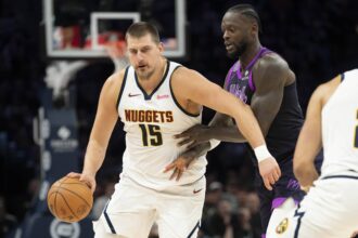 Nov 15, 2025; Minneapolis, Minnesota, USA; Denver Nuggets center Nikola Jokic (15) dribbles the ball past Minnesota Timberwolves forward Julius Randle (30) in the second half at Target Center. Mandatory Credit: Jesse Johnson-Imagn Images