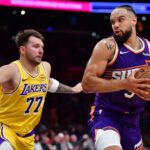 Dec 1, 2025; Los Angeles, California, USA; Phoenix Suns forward Dillon Brooks (3) moves the ball against Los Angeles Lakers guard Luka Doncic (77) during the first half at Crypto.com Arena. Mandatory Credit: Gary A. Vasquez-Imagn Images