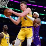 Dec 1, 2025; Los Angeles, California, USA; Los Angeles Lakers forward Dalton Knecht (4) gets the rebound against Phoenix Suns guard Jordan Goodwin (23) during the first half at Crypto.com Arena. Mandatory Credit: Gary A. Vasquez-Imagn Images