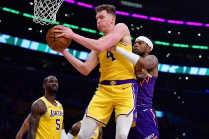 Dec 1, 2025; Los Angeles, California, USA; Los Angeles Lakers forward Dalton Knecht (4) gets the rebound against Phoenix Suns guard Jordan Goodwin (23) during the first half at Crypto.com Arena. Mandatory Credit: Gary A. Vasquez-Imagn Images