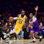 Dec 1, 2025; Los Angeles, California, USA; Los Angeles Lakers forward LeBron James (23) moves the ball against Phoenix Suns guard Jordan Goodwin (23) during the second half at Crypto.com Arena. Mandatory Credit: Gary A. Vasquez-Imagn Images