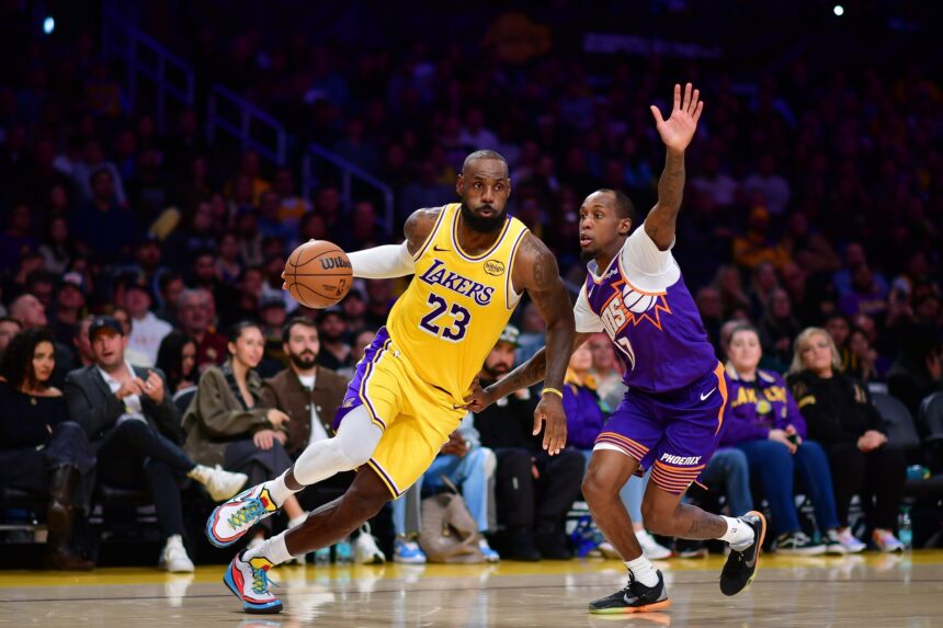 Dec 1, 2025; Los Angeles, California, USA; Los Angeles Lakers forward LeBron James (23) moves the ball against Phoenix Suns guard Jordan Goodwin (23) during the second half at Crypto.com Arena. Mandatory Credit: Gary A. Vasquez-Imagn Images