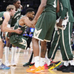 Dec 3, 2025; Milwaukee, Wisconsin, USA; Milwaukee Bucks guard AJ Green (20) and Milwaukee Bucks guard Kevin Porter Jr. (7) help Milwaukee Bucks forward Giannis Antetokounmpo (34) up after he goes down with an injury in the first half against the Detroit Pistons at Fiserv Forum. Mandatory Credit: Michael McLoone-Imagn Images