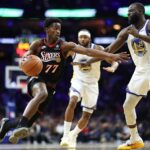 Dec 4, 2025; Philadelphia, Pennsylvania, USA; Philadelphia 76ers guard VJ Edgecombe (77) drives against Golden State Warriors forward Draymond Green (23) during the second quarter at Xfinity Mobile Arena. Mandatory Credit: Bill Streicher-Imagn Images