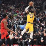 Dec 4, 2025; Toronto, Ontario, CAN; Los Angeles Lakers forward LeBron James (23) shoots the ball over Toronto Raptors forward Scottie Barnes (4) in the first half at Scotiabank Arena. Mandatory Credit: Dan Hamilton-Imagn Images