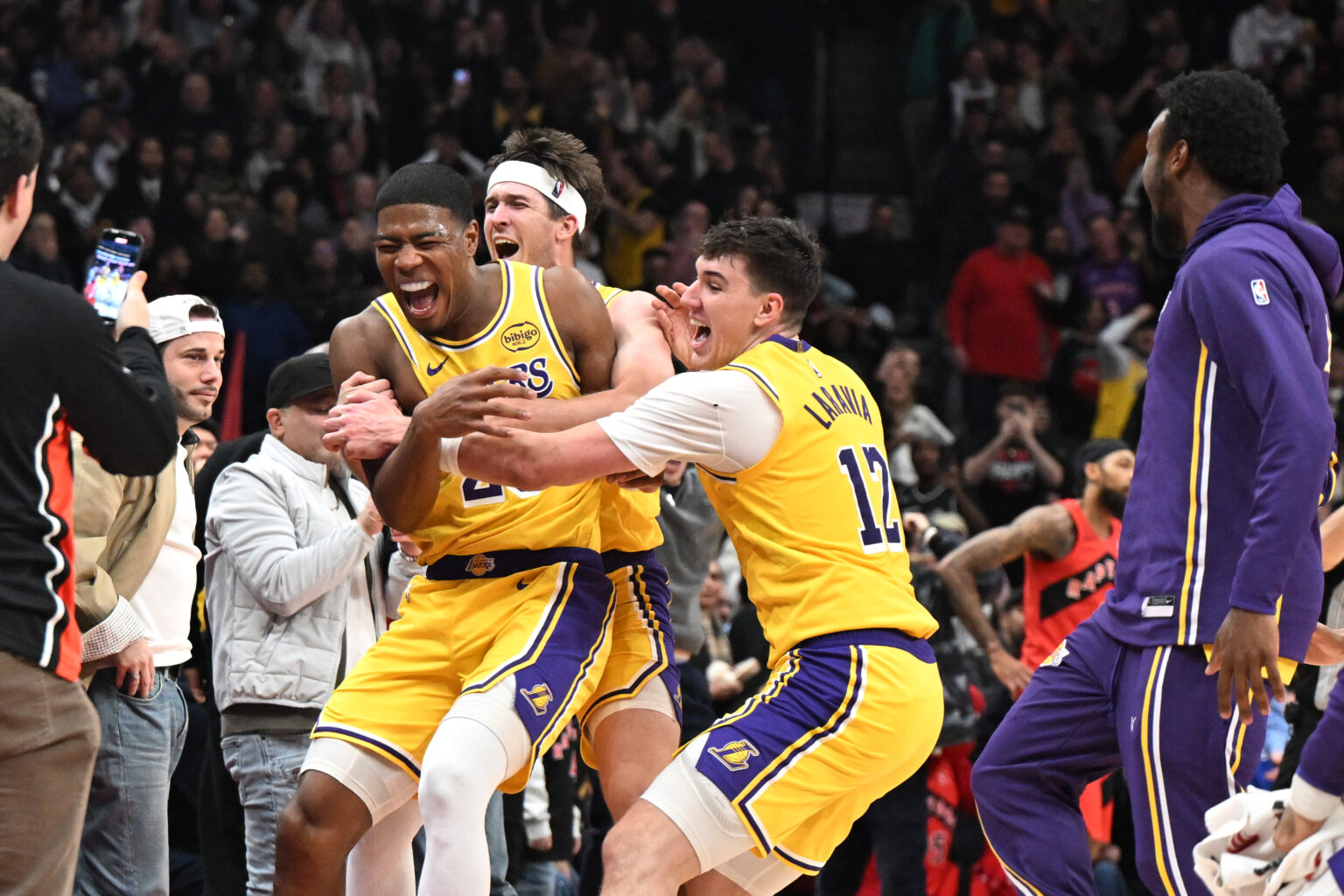 Dec 4, 2025; Toronto, Ontario, CAN; Los Angeles Lakers forward Rui Hachimura (28) celebrates with forward Jake LaRavia (12) and guard Austin Reaves (15) after scoring the game winning buzzer beating basket against the Toronto Raptos half at Scotiabank Arena. Mandatory Credit: Dan Hamilton-Imagn Images