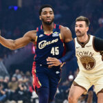Dec 6, 2025; Cleveland, Ohio, USA; Cleveland Cavaliers guard Donovan Mitchell (45) passes as Golden State Warriors guard Pat Spencer (61) defends during the first half at Rocket Arena. Mandatory Credit: Ken Blaze-Imagn Images