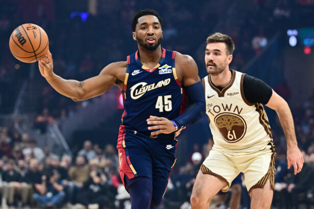 Dec 6, 2025; Cleveland, Ohio, USA; Cleveland Cavaliers guard Donovan Mitchell (45) passes as Golden State Warriors guard Pat Spencer (61) defends during the first half at Rocket Arena. Mandatory Credit: Ken Blaze-Imagn Images