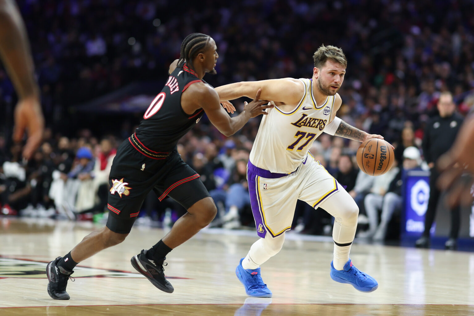 Dec 7, 2025; Philadelphia, Pennsylvania, USA; Los Angeles Lakers guard Luka Doncic (77) dribbles past Philadelphia 76ers guard Tyrese Maxey during the second quarter at Xfinity Mobile Arena. Mandatory Credit: Bill Streicher-Imagn Images