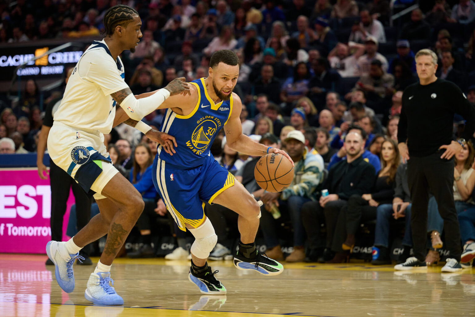 Dec 12, 2025; San Francisco, California, USA; Golden State Warriors guard Stephen Curry (30) drives to the basket against Minnesota Timberwolves forward Jaden McDaniels (3) as head coach Chris Finch looks on during the second quarter at Chase Center. Mandatory Credit: Robert Edwards-Imagn Images