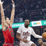 Dec 19, 2025; Cleveland, Ohio, USA; Cleveland Cavaliers guard Darius Garland (10) passes the ball past Chicago Bulls forward-center Zach Collins (12) during the first quarter at Rocket Arena. Mandatory Credit: Scott Galvin-Imagn Images